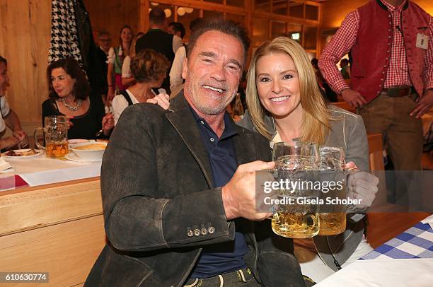 Arnold Schwarzenegger and his girlfriend Heather Milligan visit the Schuetzen Festzelt during the Oktoberfest at Theresienwiese on September 27, 2016...