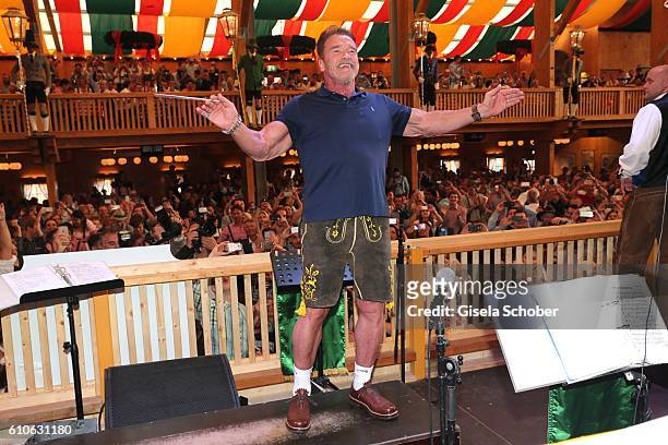Arnold Schwarzenegger conducts the orchestra at the Schuetzen Festzelt during the Oktoberfest at Theresienwiese on September 27, 2016 in Munich,...