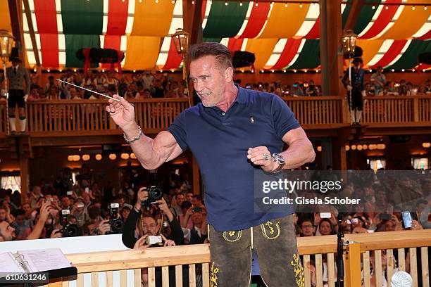 Arnold Schwarzenegger conducts the orchestra at the Schuetzen Festzelt during the Oktoberfest at Theresienwiese on September 27, 2016 in Munich,...