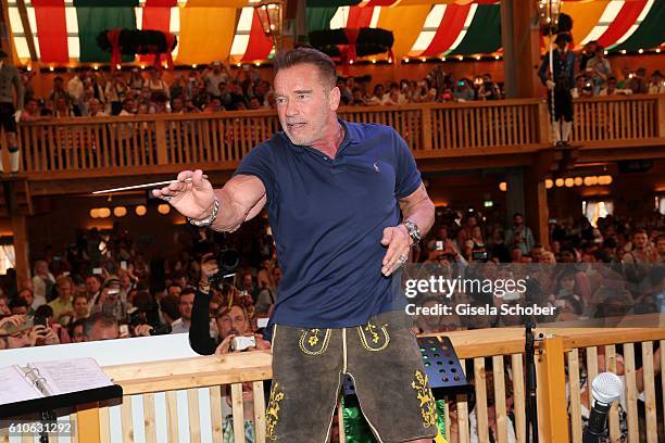 Arnold Schwarzenegger conducts the orchestra at the Schuetzen Festzelt during the Oktoberfest at Theresienwiese on September 27, 2016 in Munich,...