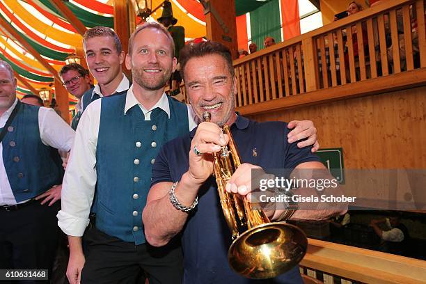 Arnold Schwarzenegger plays a trumpet during his visit of the Schuetzen Festzelt during the Oktoberfest at Theresienwiese on September 27, 2016 in...