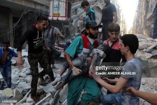 Medic carries the body of a boy after he was pulled from the rubble following a government forces air strike on the rebel-held al-Shaer neighbourhood...