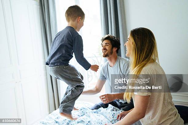 happy family waking up in the morning, playing in bed - father and child and pillow fight stock pictures, royalty-free photos & images