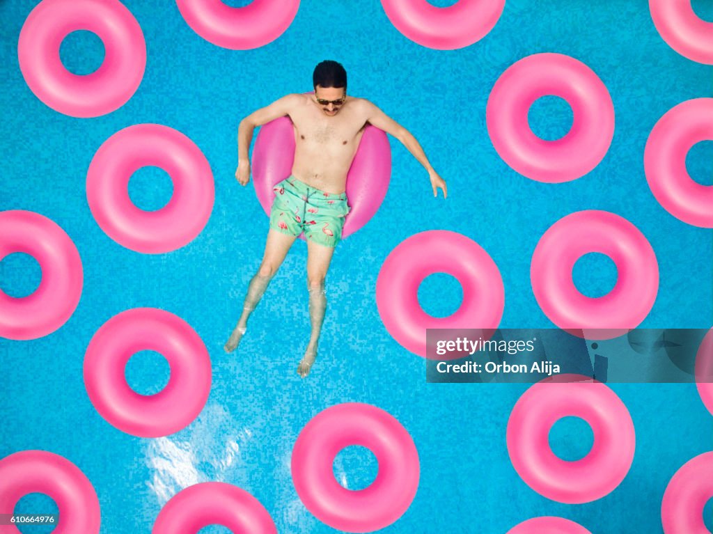 Carefree man on ring in swimming pool