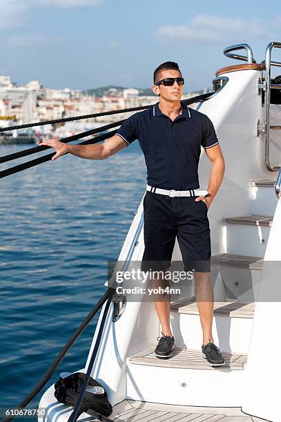 male crew member standing on yacht - sailing club stock pictures, royalty-free photos & images