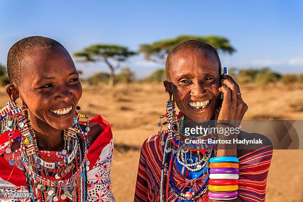 woman from maasai tribe using mobile phone, kenya, africa - acacia tree stock pictures, royalty-free photos & images