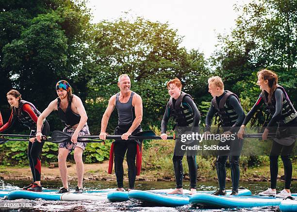 learning to paddleboard - paddleboarding team stock pictures, royalty-free photos & images