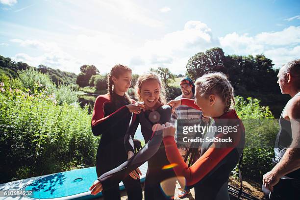 wetsuit struggles! - paddleboarding team stock pictures, royalty-free photos & images