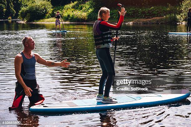 learning to paddleboard - life jacket stock pictures, royalty-free photos & images