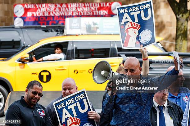 New York City taxi cab drives by as Syed Manzar, who drives for both Uber and Lyft, speaks during a rally to call on the New York City Taxi and...
