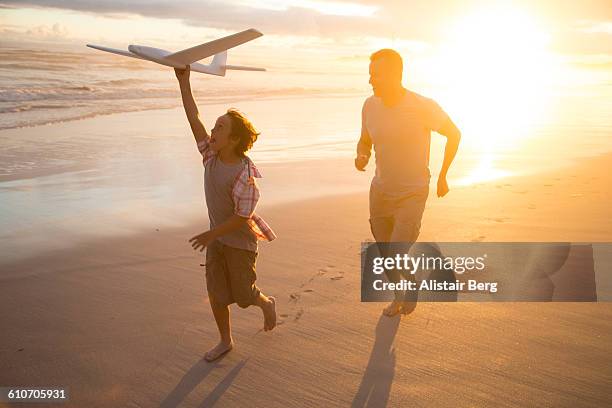 family playing together on a beach - family sunset stock pictures, royalty-free photos & images