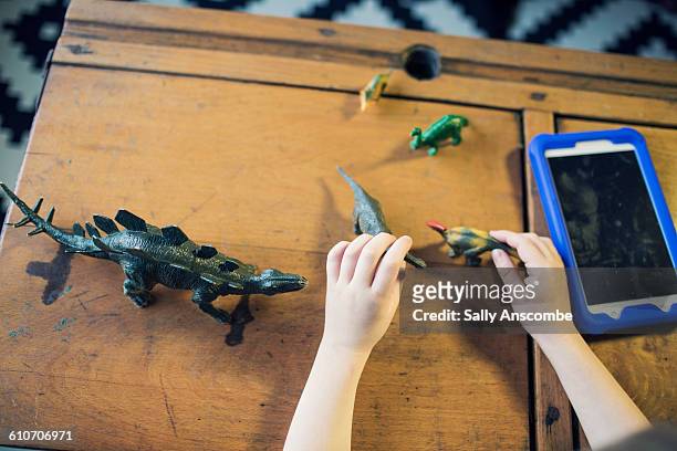 child playing with toy dinosaurs - dinosaur toy i stock pictures, royalty-free photos & images
