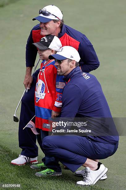 Hockey player Jeremy Roenick and swimmer Michael Phelps pose with a young fan during the 2016 Ryder Cup Celebrity Matches at Hazeltine National Golf...