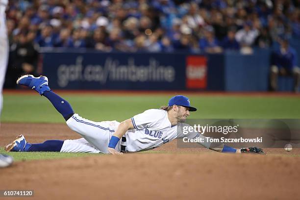 Josh Donaldson of the Toronto Blue Jays dives but cannot get to a single through the hole hit by Michael Bourn of the Baltimore Orioles in the fourth...