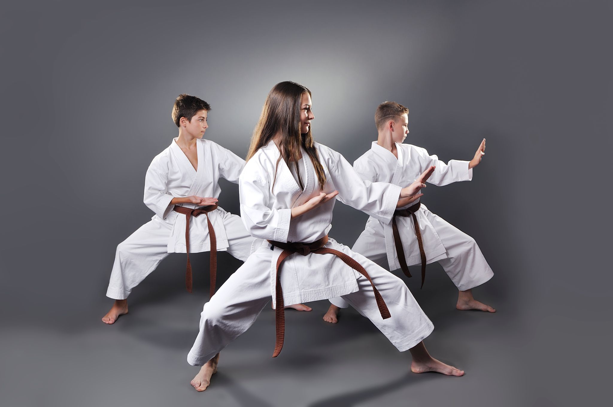 One female and two male brown belt karate doing kata One female and two male brown belt karate doing kata