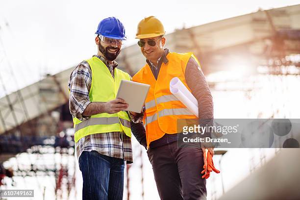 experts having meeting on construction site and using digital tablet - bridge built structure stock pictures, royalty-free photos & images