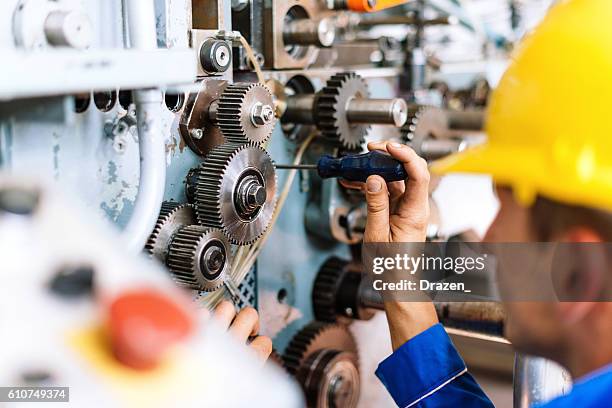 machinist precisely setting up cog wheels - machineonderdeel stockfoto's en -beelden