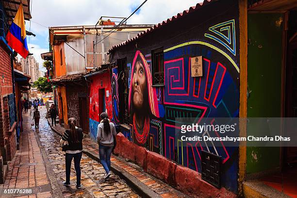 bogotá, colombia - los colombianos locales caminan por la estrecha, colorida y adoquinada calle del embudo en el histórico distrito de la candelaria - calle del embudo fotografías e imágenes de stock