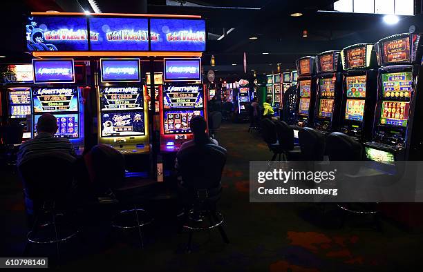 Customers sit at poker machines in the gaming room at the Vikings Club in Canberra, Australia, on Monday, Sept. 26, 2016. Despite having less than...