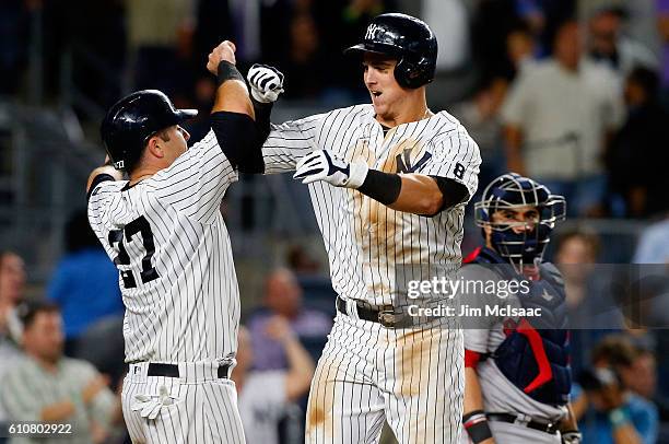 Tyler Austin of the New York Yankees celebrates his seventh inning two-run home run with teammate Austin Romine as Sandy Leon of the Boston Red Sox...