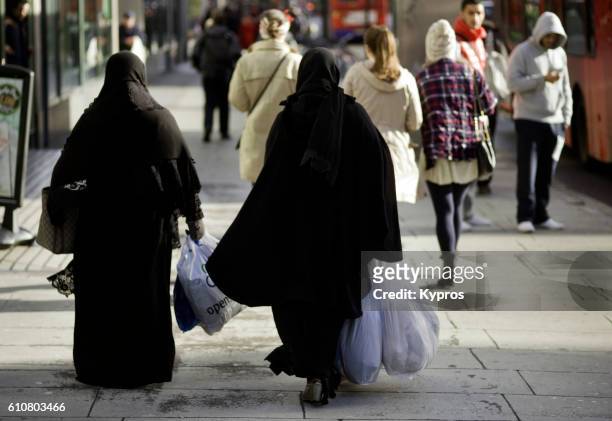 europe, uk, england, london, view of two muslim women wearing burka's cruising edgware road carrying plastic shooting bags - niqab stockfoto's en -beelden