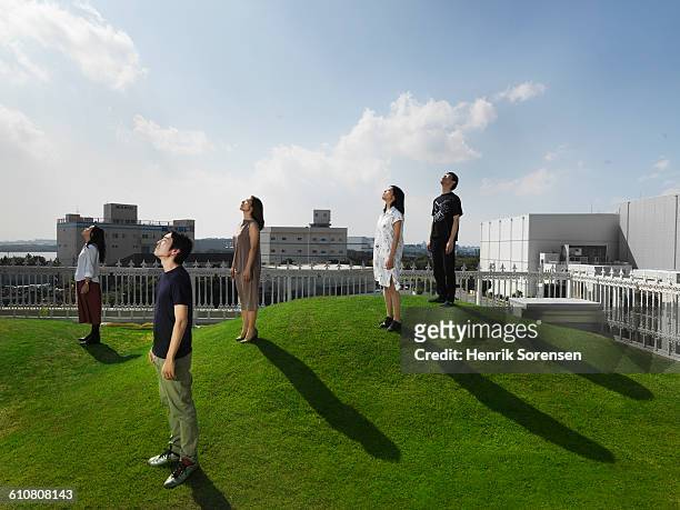 5 young japanese people looking up - japanese woman looking up stockfoto's en -beelden
