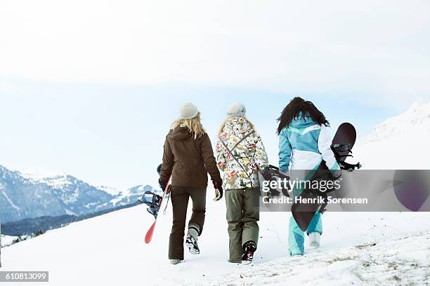 3 young women on winter holiday - skifahren und snowboarden stock-fotos und bilder