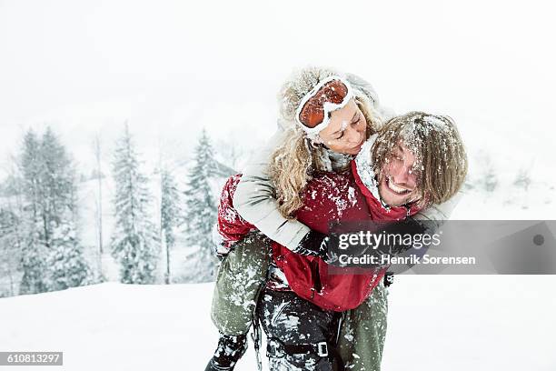 young couple in the snow - snow boarding stock-fotos und bilder