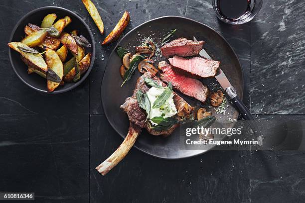tomahawk beef steak with mushrooms, burrata and sage potato wedges - food photography from above stock-fotos und bilder