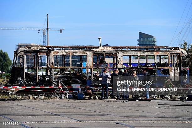 Street artists work at the NDSM shipyards, in Amsterdam, on September 27, 2016. / AFP / EMMANUEL DUNAND