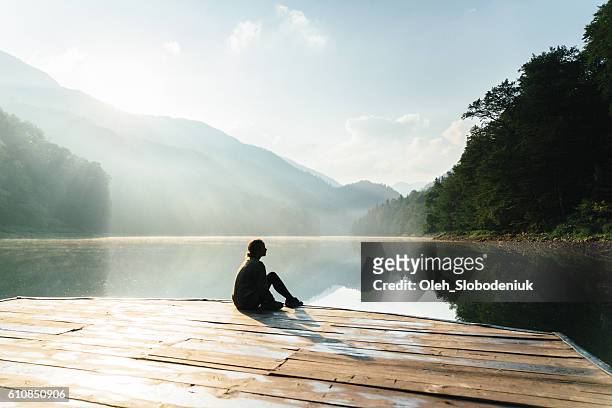 woman near the lake in mountains - lake dock stock pictures, royalty-free photos & images