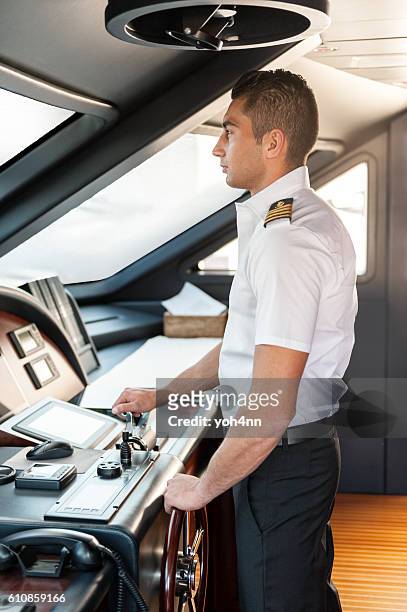 captain operating yacht - team captain stock pictures, royalty-free photos & images