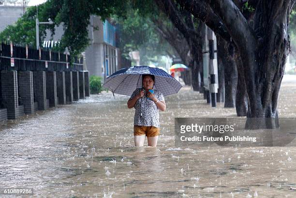 Pedestrian walks on September 28, 2016 in Fuzhou, China. Typhoon Megi has brought torrential rains to the province, flooding towns and disrupting...