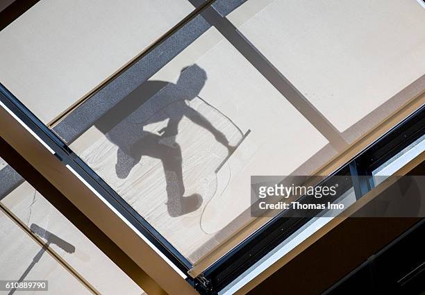 Berlin, Germany Shadow of a worker who cleans a glass roof on June 23, 2016 in Berlin, Germany.