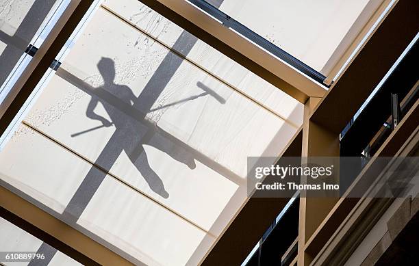 Berlin, Germany Shadow of a worker who cleans a glass roof on June 23, 2016 in Berlin, Germany.