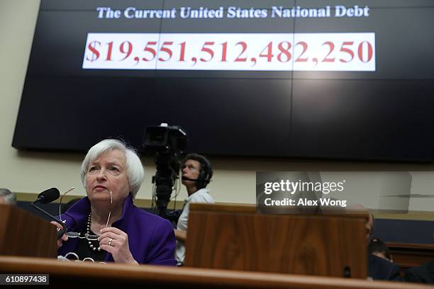 As the number of the current U.S. National debt is seen on a screen, Federal Reserve Board Chair Janet Yellen testifies during a hearing before the...