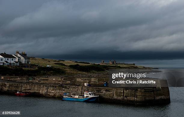 Dark storm clouds form over Dunstanburgh Castle on the coast of Northumberland as seen from the fishing port of Craster on September 28, 2016 in...