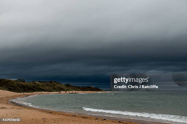 Beach houses sit on top of sand dunes in Embleton Bay as dark storm clouds form on the coast of Northumberland on September 28, 2016 in Craster,...