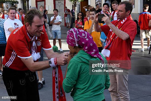 Bayern supporter pictured with a beggar in Madrid. Several Bayern Munich supporters have been accused of humiliating beggars at Plaza Ópera of Madrid...