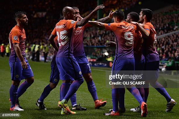 Manchester City's Brazilian midfielder Fernandinho and teammates congratulate Manchester City's English midfielder Raheem Sterling for scoring his...