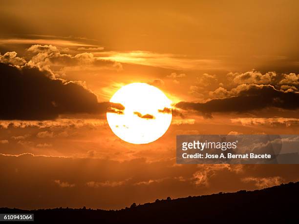 full frame of a beautiful colorful orange sky with clouds at sunset - zeitstrahl stock-fotos und bilder