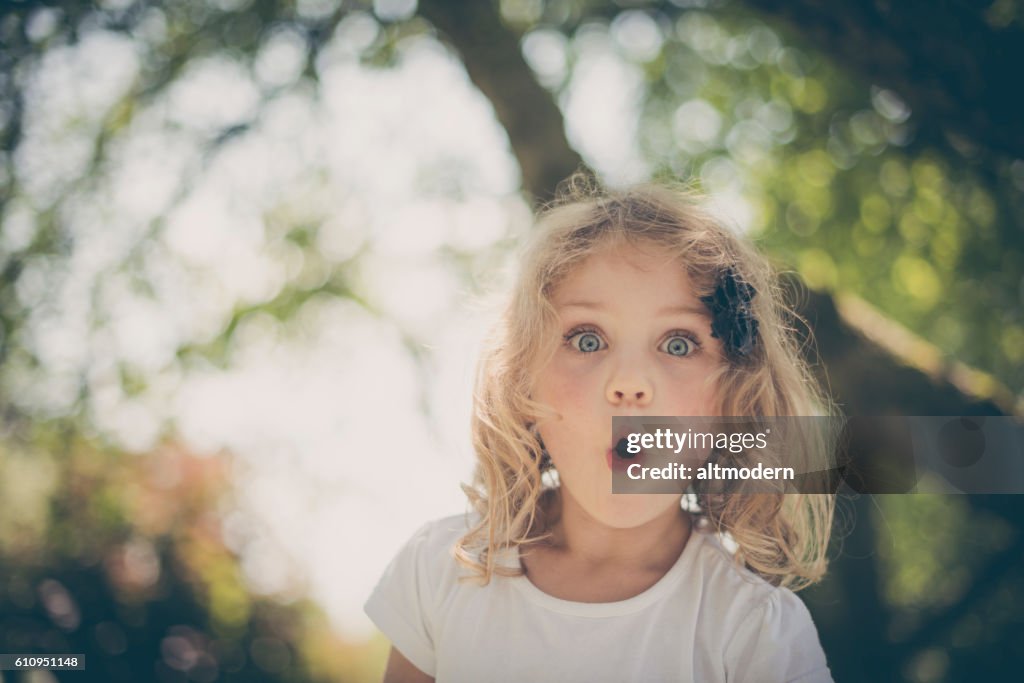 Kleine überrascht blonde Mädchen mit blauen Augen