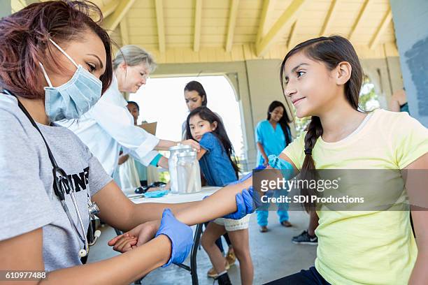 doctor examines preteen patient at free clinic - criancas free imagens e fotografias de stock