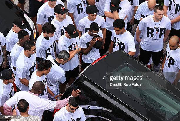 Miami Marlins players and members of the Marlins organization and their fans surround the hearse carrying Miami Marlins pitcher Jose Fernandez to pay...