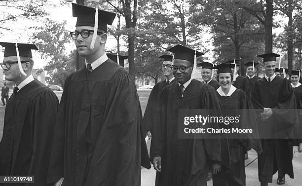 American Civil Rights activist and James Meredith walks with his University of Mississippi classmates during the school's graduation ceremony,...