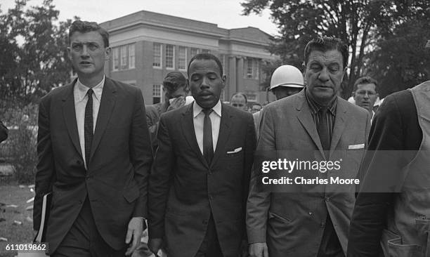 American Civil Rights activist and student James Meredith is escorted by Assistant Attorney General for Civil Rights John Doar and Chief US Marshal...