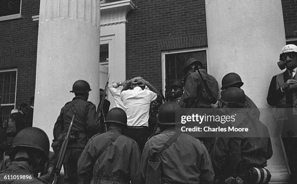 Marshals and soldiers escort several arrested pre-segregationists into the Lyceum Building on the University of Mississippi campus during an ongoing...