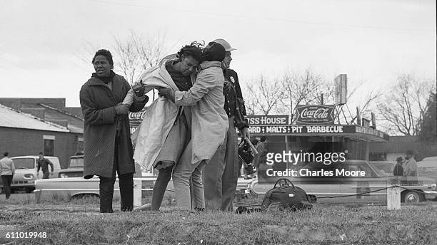 Two people lift the unconscious body of Civil Rights activist Amelia Boynton at the base of the Edmund Pettus Bridge during the first Selma to...