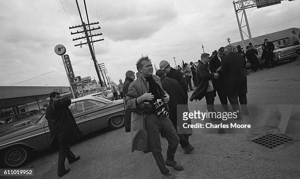 American photographer Charles Moore waits for marchers at base of the Edmund Pettus Bridge, Selma, Alabama, March 7, 1965. Once the marchers crossed...