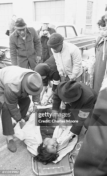 Medics treat the unconscious body of Civil Rights activist Amelia Boynton on a stretcher near the Edmund Pettus Bridge during the first Selma to...